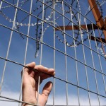 Hand behind bars